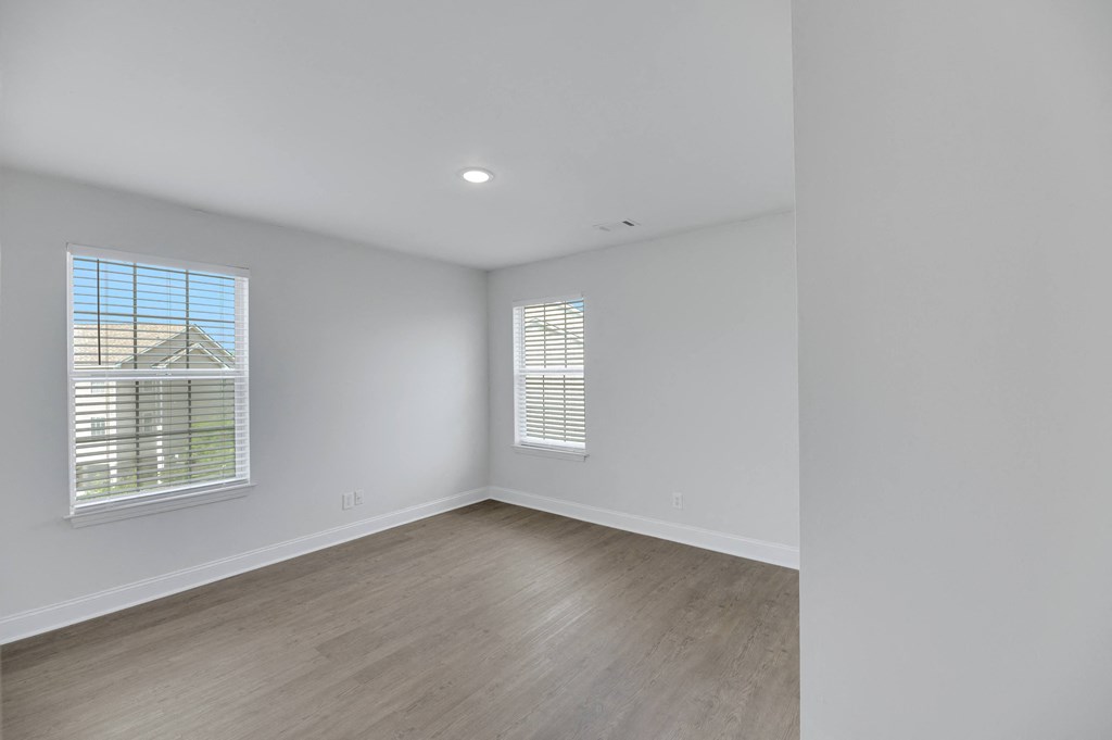 an empty living room with white walls and wood floors