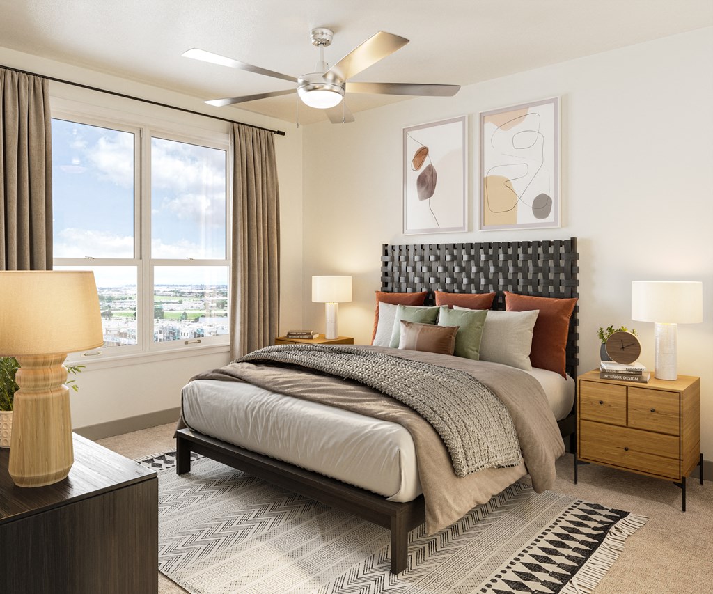 a bedroom with a large window and a ceiling fan