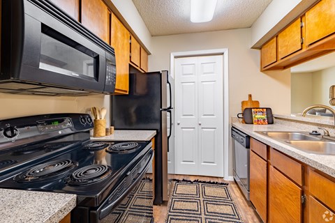 A kitchen with a black stove and a black microwave.