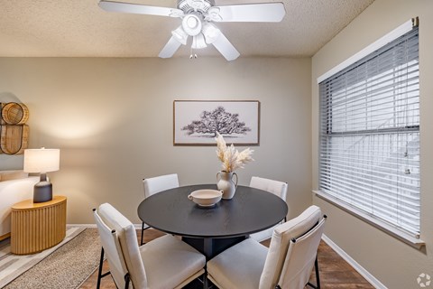 A dining room with a round table and chairs.