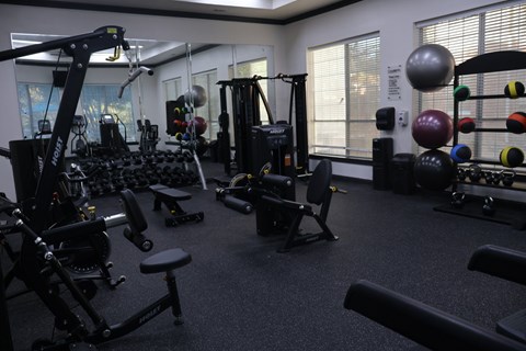 Fitness center with strength training equipment and weights at Clearwater Creek Apartments, Richardson, Texas