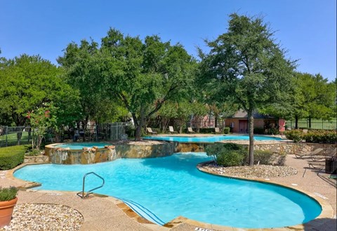 Lagoon style pool with waterfall and landscaping at Seven Oaks Apts Apartments, Texas