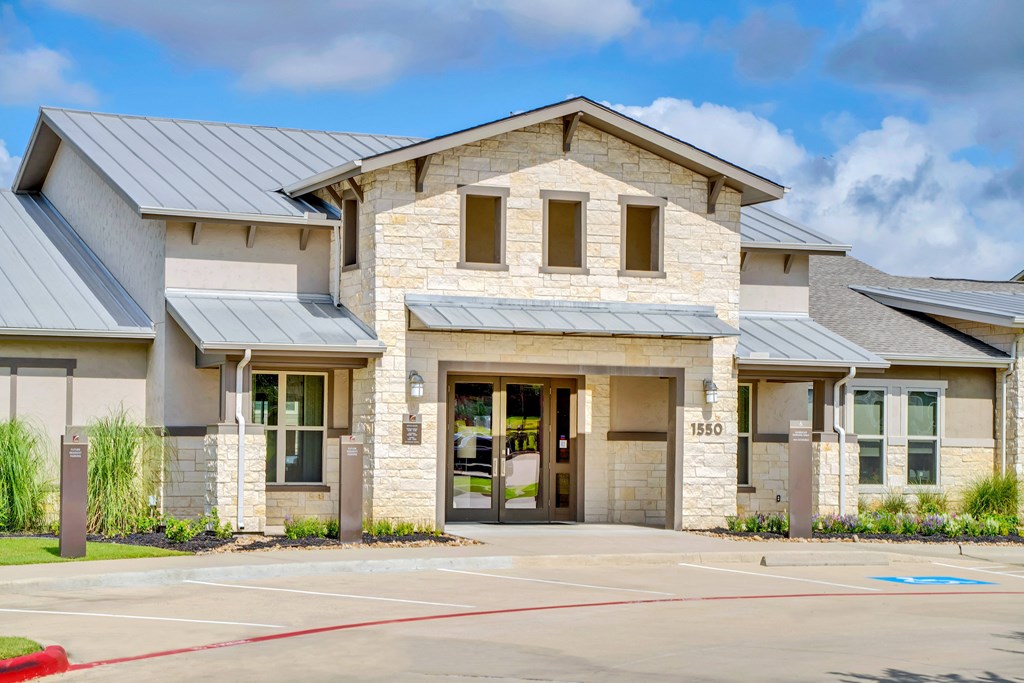 the exterior of a building with a parking lot and a driveway