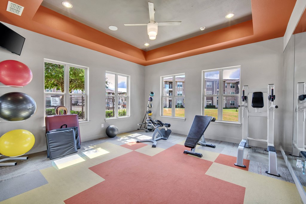 a workout room with weights and cardio equipment at the grove apartments