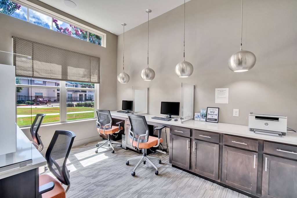 an office with two desks and chairs and a window