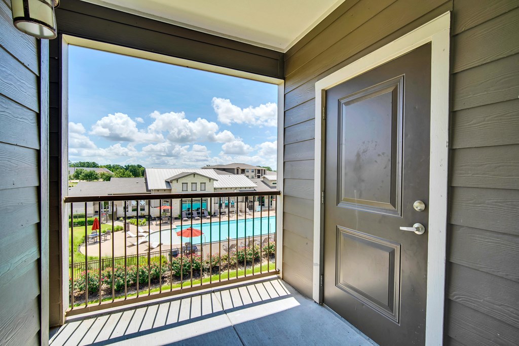 an open door to a balcony with a swimming pool