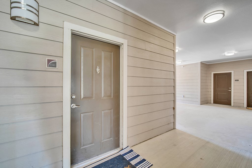 the front door of a house is open to a hallway with a door to a