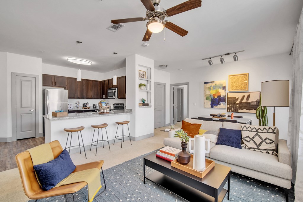 a living room and kitchen with a ceiling fan