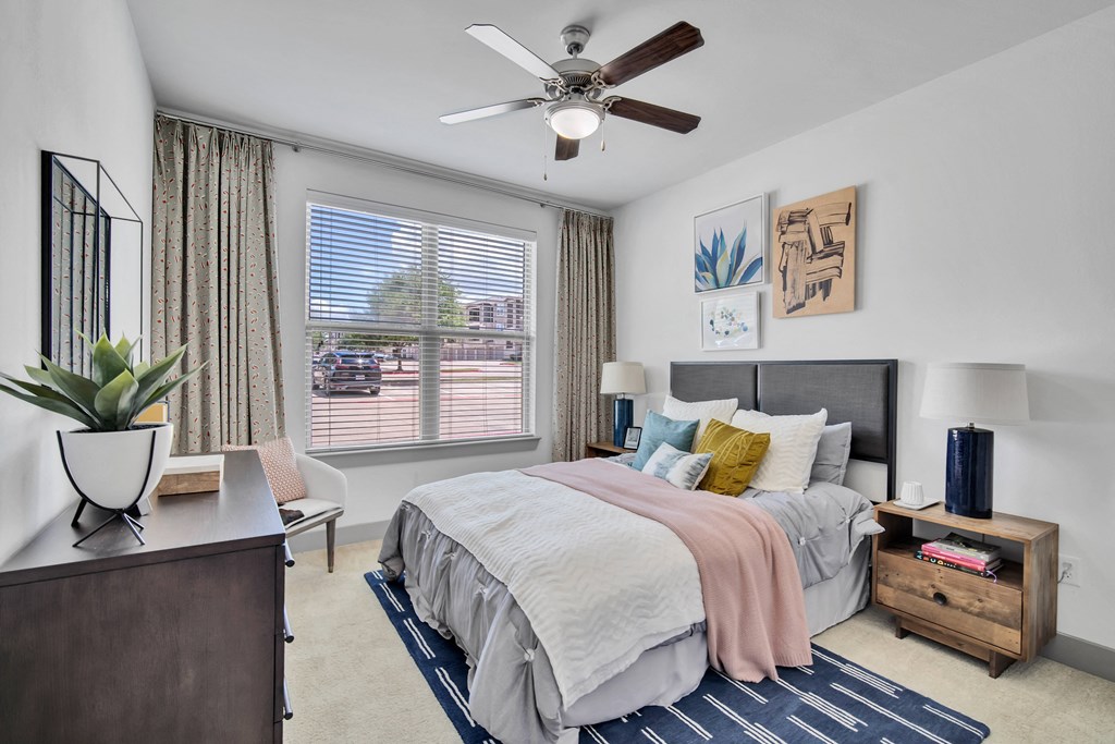 a bedroom with a large bed and a ceiling fan