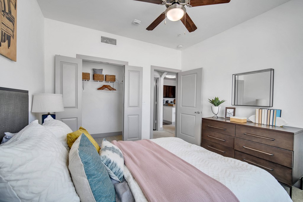 a bedroom with a large bed and a ceiling fan