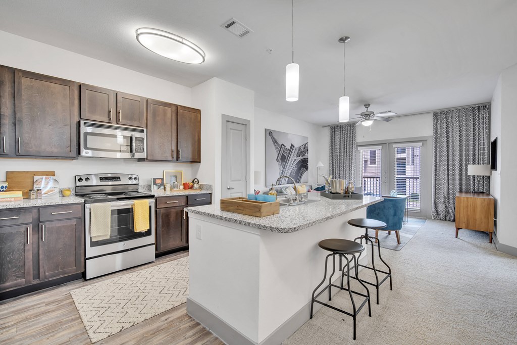 an open kitchen and living room with a large island and stools