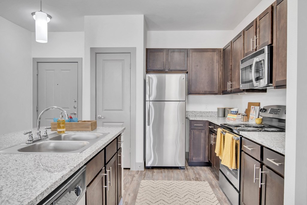 an empty kitchen with stainless steel appliances and granite counter tops