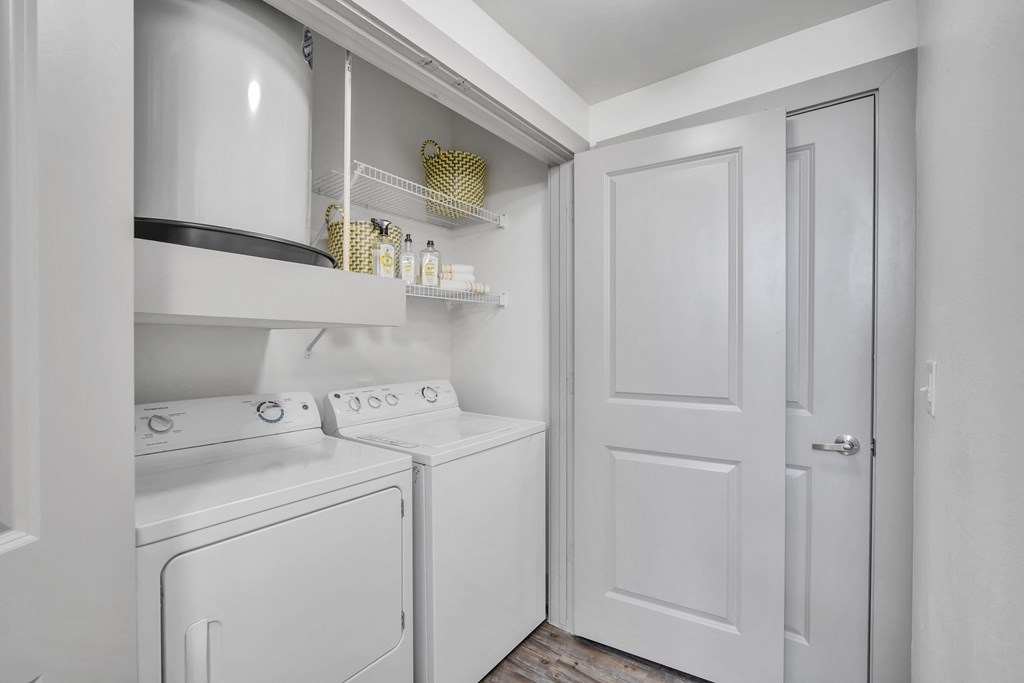 a small laundry room with white appliances and a white door