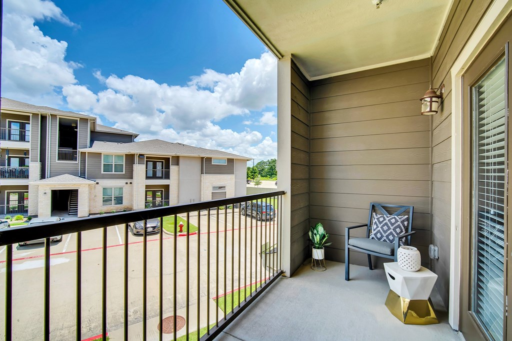 a balcony with a chair and a table