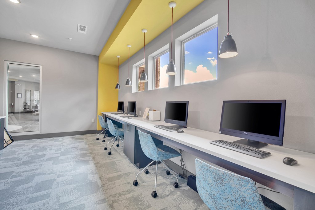 a computer room with three computers on a long desk