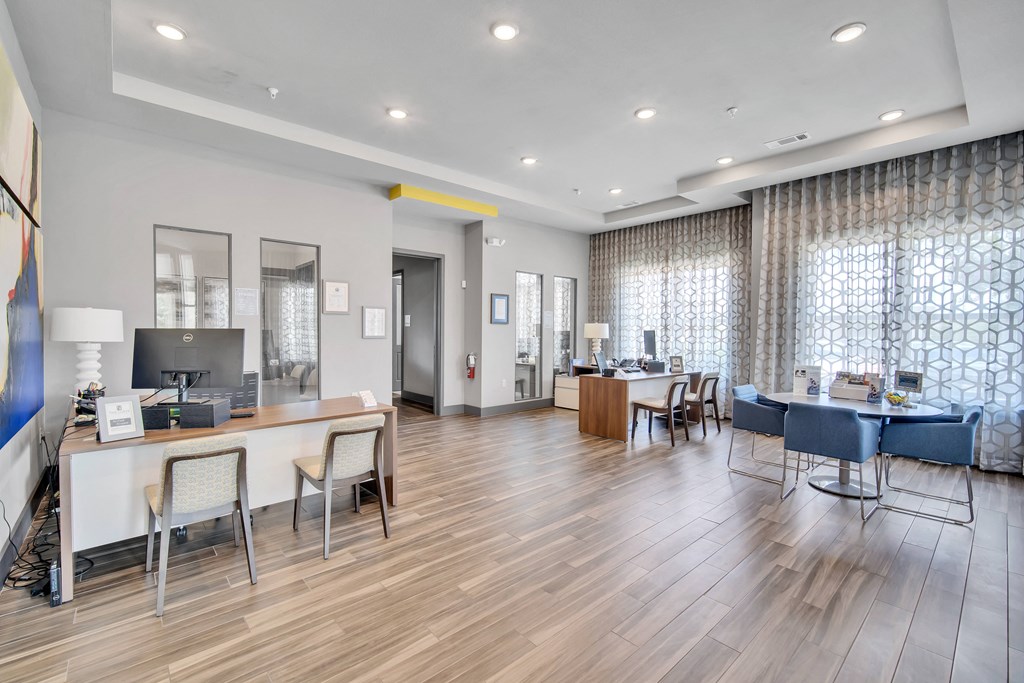 a communal area with tables and chairs and a living room with couches