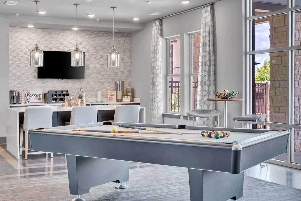 a game room with a pool table and a bar