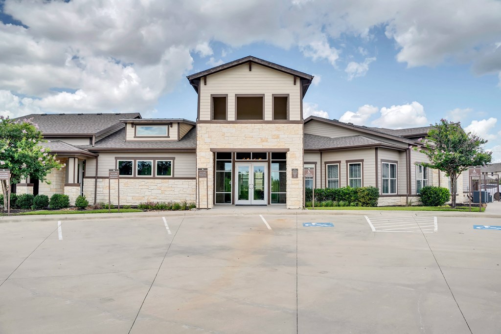 an empty parking lot in front of a large house