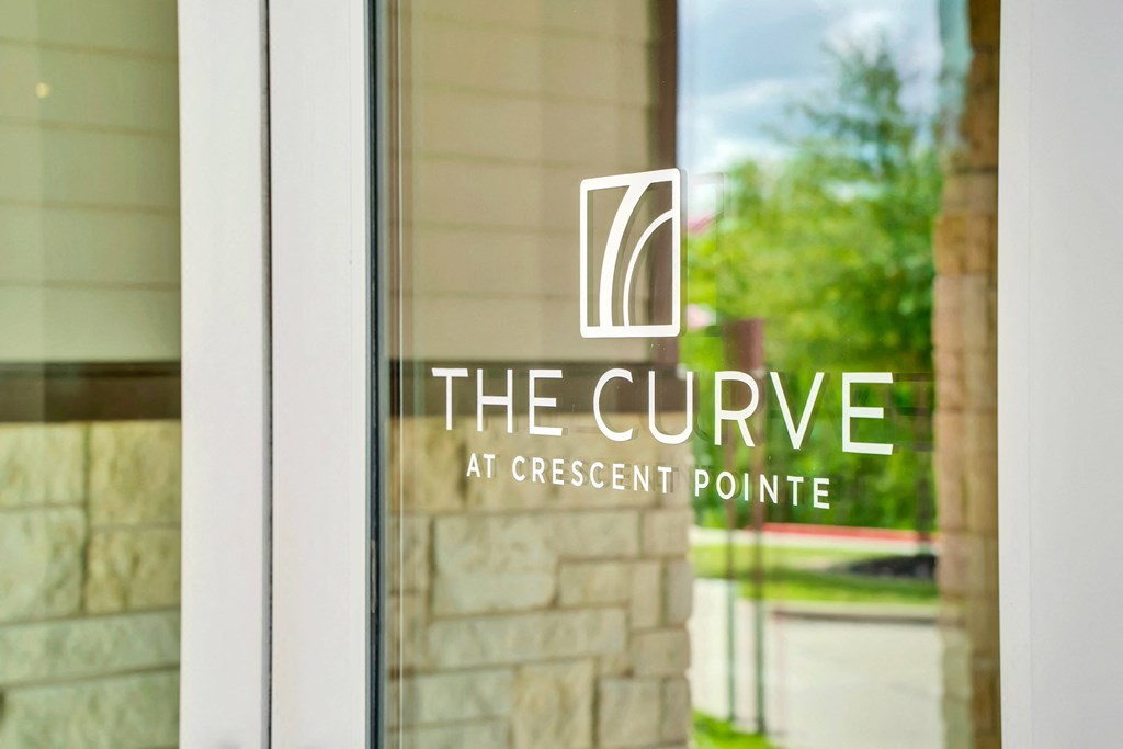 the cure at crescent pointe logo on glass door