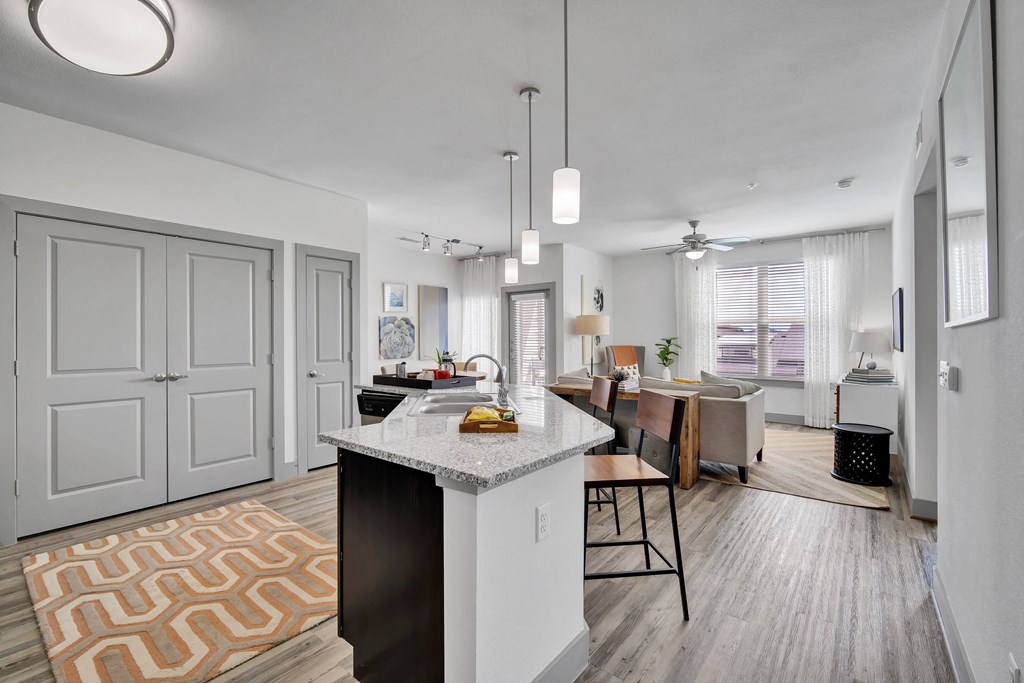an open kitchen and living room with a large island and a dining room