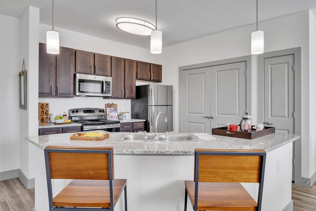 a kitchen with a large counter top with two stools