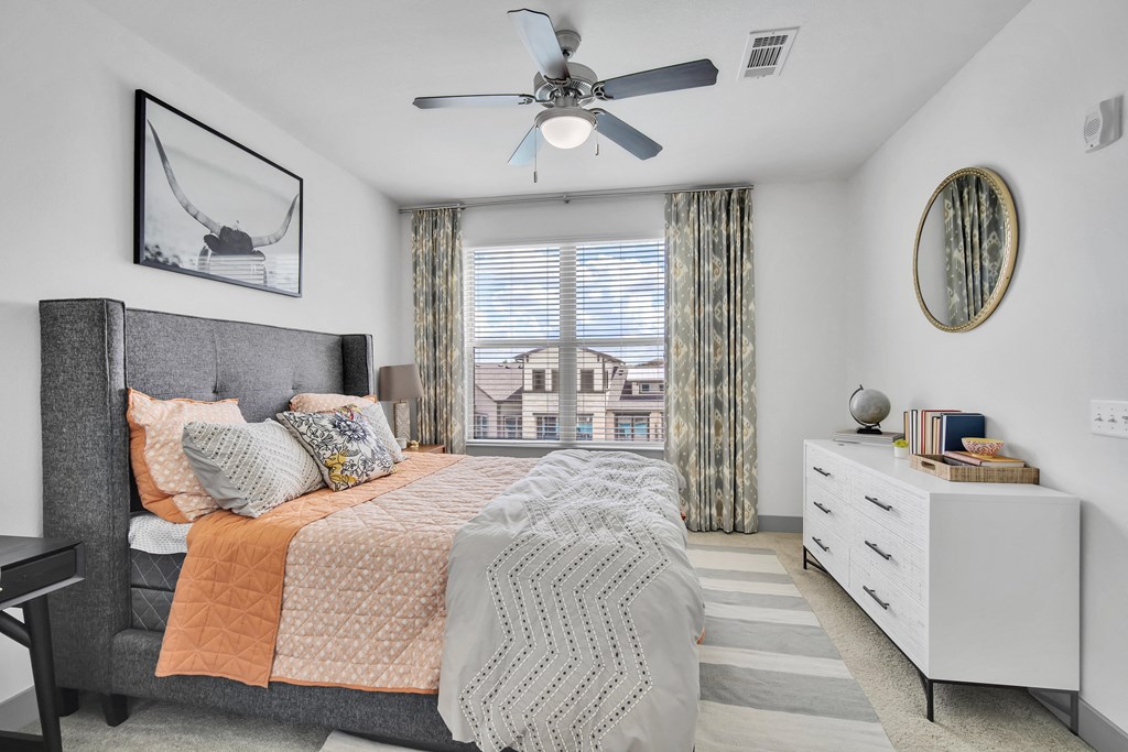 a bedroom with a bed and a ceiling fan