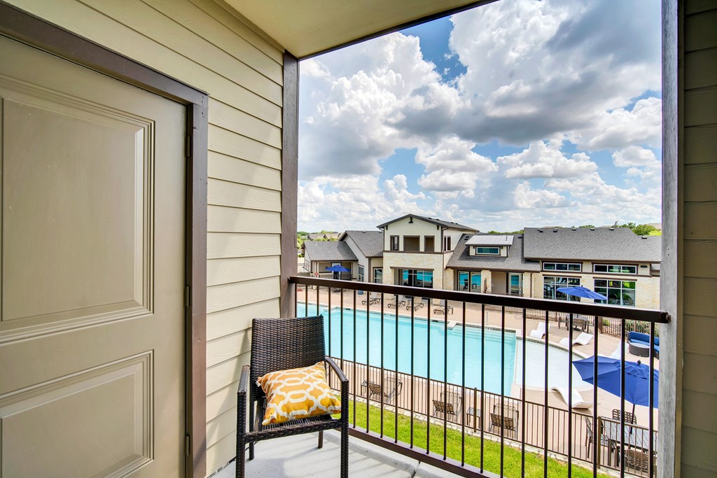 the view of a pool from a balcony with a chair