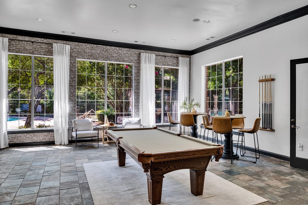 a game room with a pool table and windows