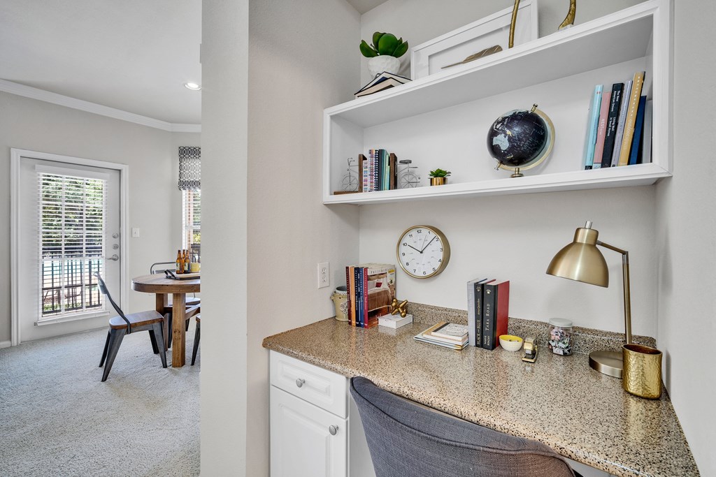 a home office with a desk and a clock on a shelf