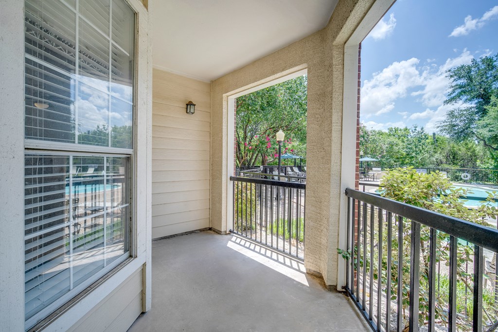 the view from the balcony of a home with a door open to a patio