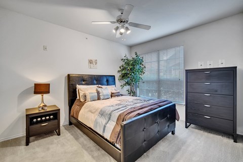 Bedroom with upholstered bed and dresser at Seven Oaks Apts Apartments, Garland, TX