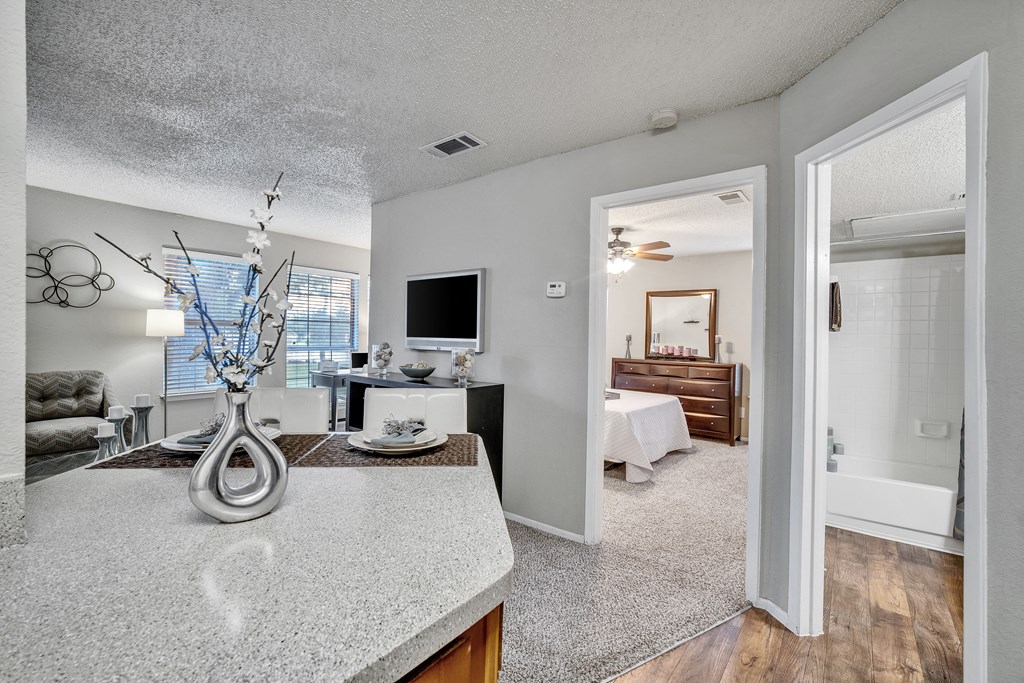 an open living room and kitchen with a view of a bedroom and a bathroom