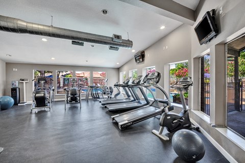 Fitness center with cardio equipment and free weights at Highland Park Apartments, Fort Worth