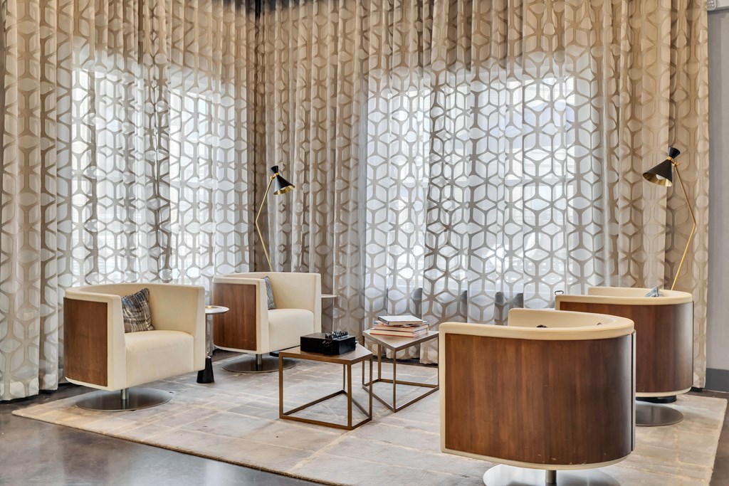 a lobby with chairs and tables and a curtain