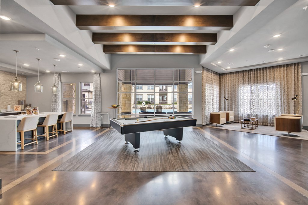 a large living room with a pool table in the middle
