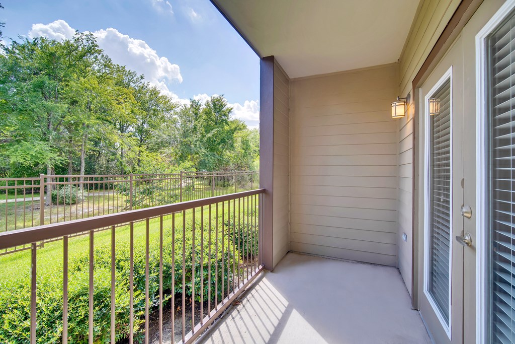 a balcony with a view of a yard and trees