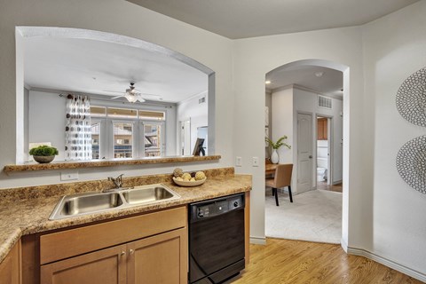 a kitchen with a sink and a window and a dining room