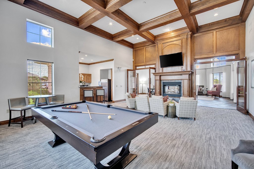 a community room with a pool table and a fireplace