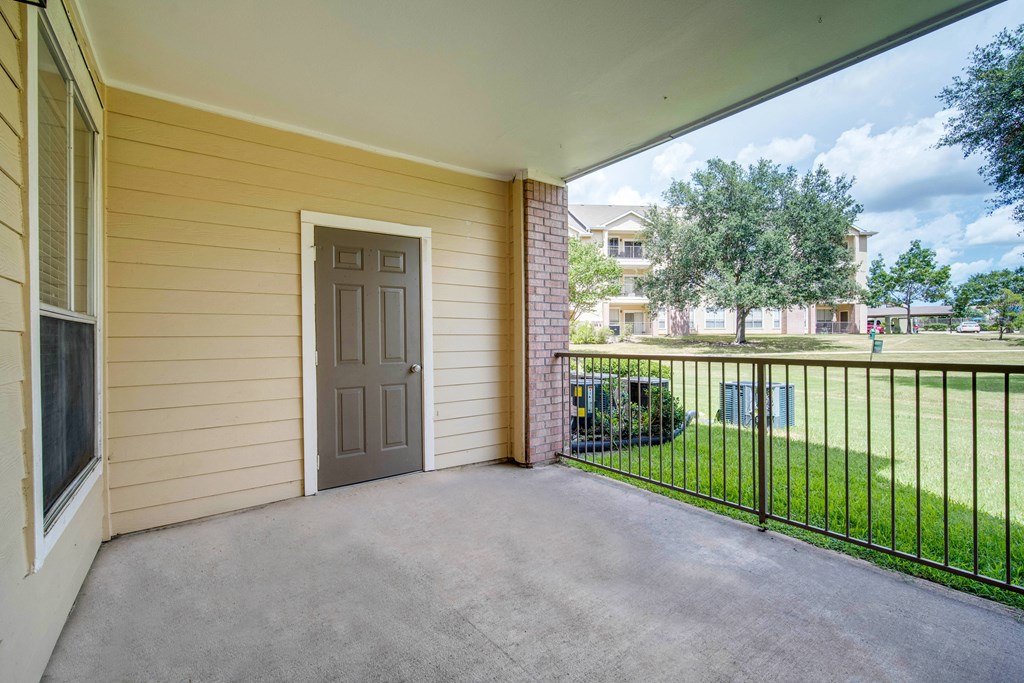 the private patio of a home with a door to the yard