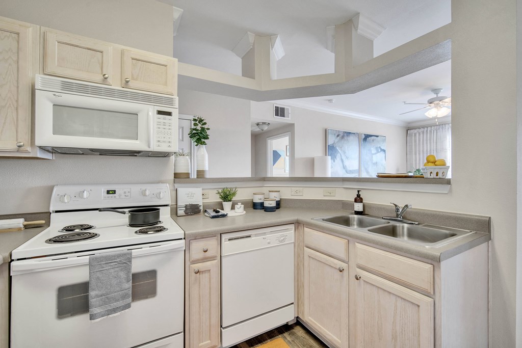 a kitchen with white appliances and wooden cabinets
