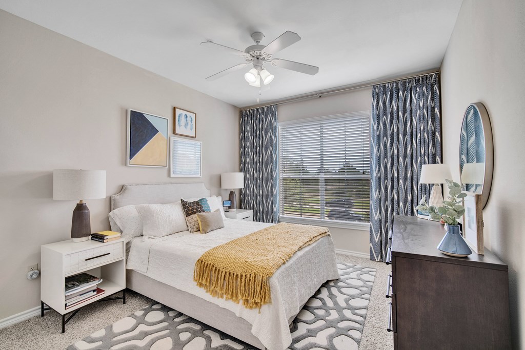a bedroom with a large bed and a ceiling fan