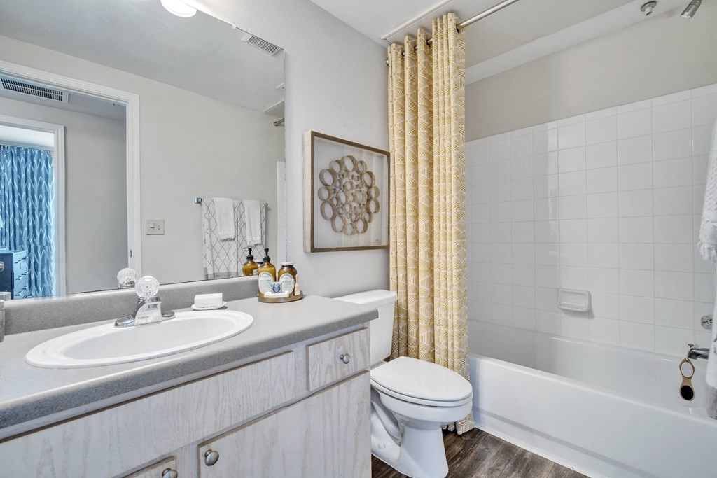 a bathroom with a shower curtain and a toilet and a sink