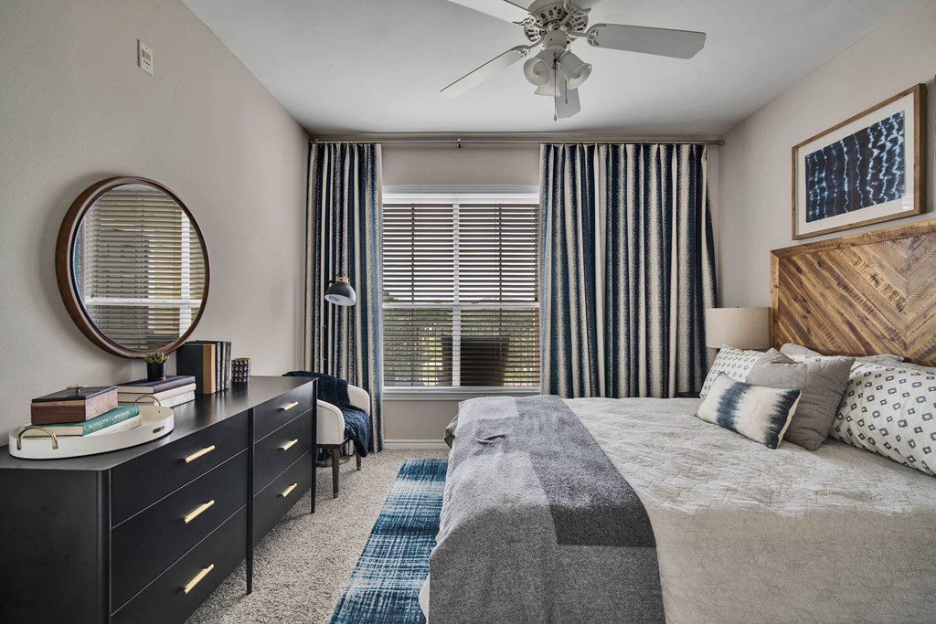 a bedroom with a large bed and a ceiling fan