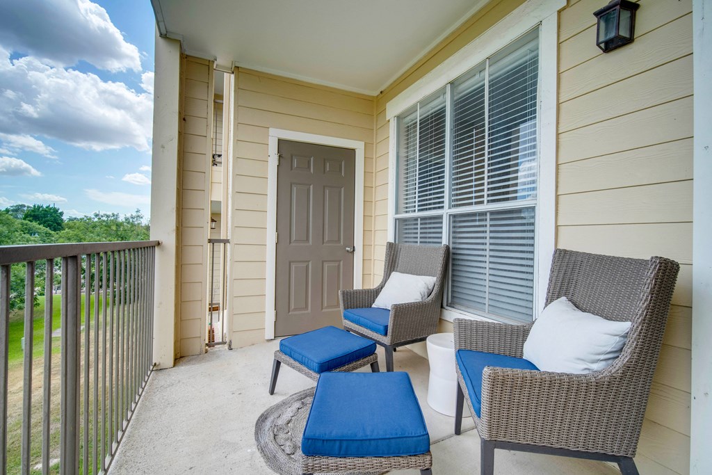a patio with two chairs and a door to a house