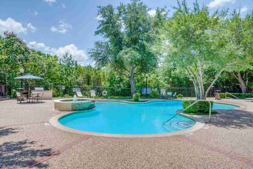 a swimming pool with trees and a fence around it