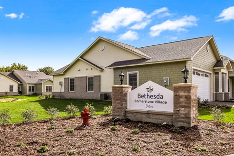the estates at bethesda connector village sign in front of a house