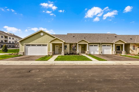 a house with two garage doors and a street in front of it