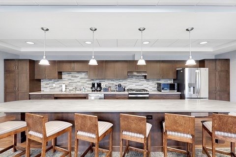 a kitchen with a large island with chairs and a counter top