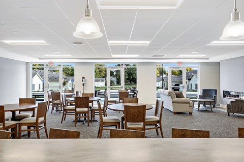 a large dining room with tables and chairs and a fireplace