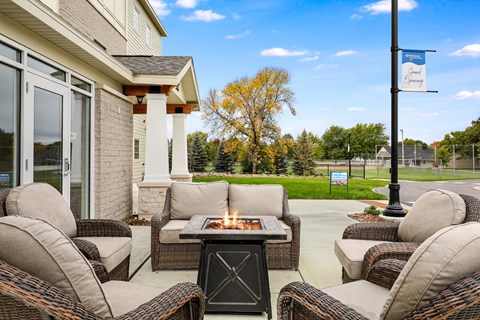 the patio of a home with couches and a fire pit